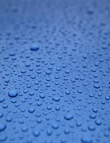 WATER DROPLETS ON BLUE METALLIC SURFACE