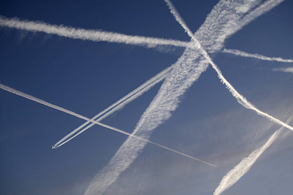 AIRCRAFT VAPOUR TRAILS AGAINST CLEAR BLUE SKY