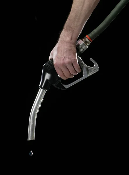 HAND HOLDING GAS PUMP ON BLACK BACKGROUND — Stock Photo, Image