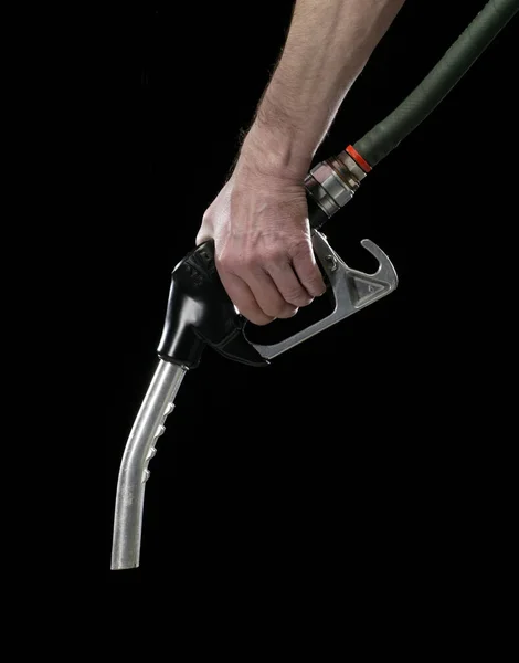 HAND HOLDING GAS PUMP ON BLACK BACKGROUND — Stock Photo, Image