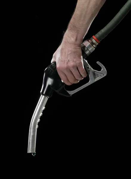 HAND HOLDING GAS PUMP WITH SINGLE DROP OF FUEL ON BLACK BACKGROU — Stok Foto