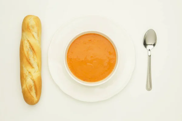 SOUP DE TOMATO SUR PLAQUE BLANCHE AVEC Pain et cuillère à soupe français — Photo