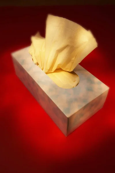 BOX OF TISSUES ON RED BACKGROUND