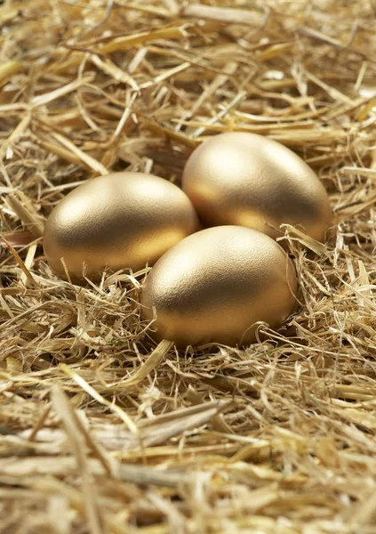 THREE GOLD EGGS IN NEST OF STRAW