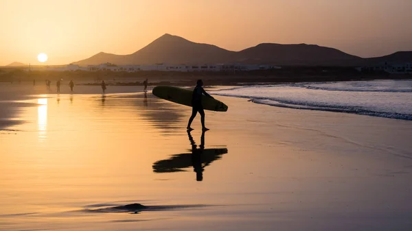Gün batımında, Kanarya Adası Famara sahilde bir sörfçü silüeti