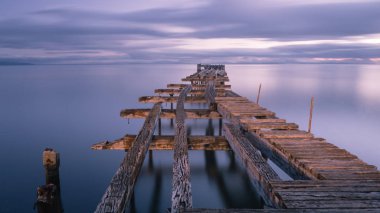 Punta Arenas, Şili Pasifik Okyanusu üzerinde eski dock eski kırık aşağı ahşap iskele. günbatımı