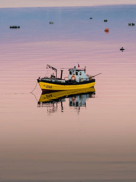 Küçük tekne şaşırtıcı güneş altında sakin su üzerinde yüzen balık tutma