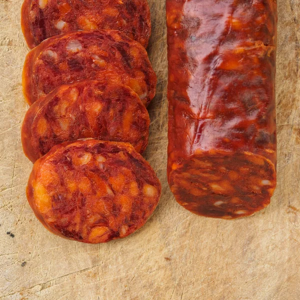 Chorizo ibérique, chorizo espagnol ou saucisse espagnole coupée en tranches sur une planche de bois. Plat typique espagnol — Photo