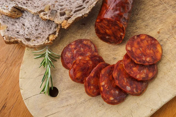 Iberische Chorizo, spanische Chorizo oder spanische Wurst in Scheiben geschnitten auf einem Holzbrett mit rustikalem Brot — Stockfoto