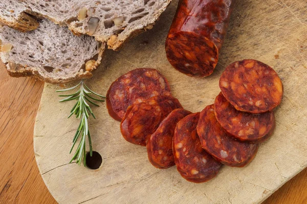 İber chorizo, İspanyol chorizo veya İspanyol sosis rustik ekmek ile ahşap bir tahta üzerinde dilimler halinde kesilmiş
