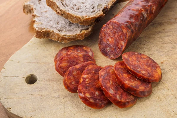 Iberische Chorizo, spanische Chorizo oder spanische Wurst in Scheiben geschnitten auf einem Holzbrett mit rustikalem Brot — Stockfoto