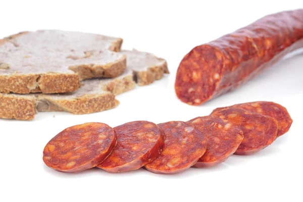 Iberische Chorizo, spanische Chorizo oder spanische Wurst mit Scheiben übereinander auf weißem Hintergrund mit Spiegelung mit rustikalem Brot, typische Tapa — Stockfoto
