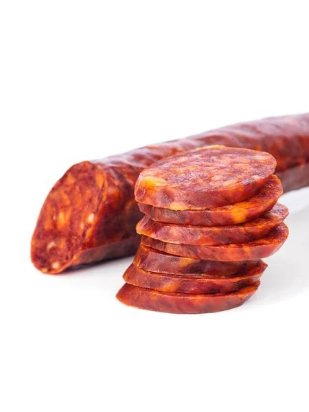 Iberische Chorizo, spanische Chorizo oder spanische Wurst mit Scheiben übereinander auf weißem Hintergrund mit seinem Spiegelbild, typische Tapa — Stockfoto