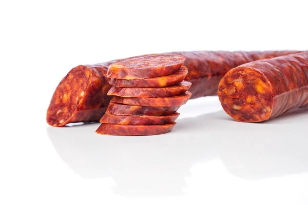 Iberische Chorizo spanische Chorizo oder spanische Wurst mit ihren Scheiben übereinander gelegt auf weißem Hintergrund mit seinem Spiegelbild typische Tapa — Stockfoto