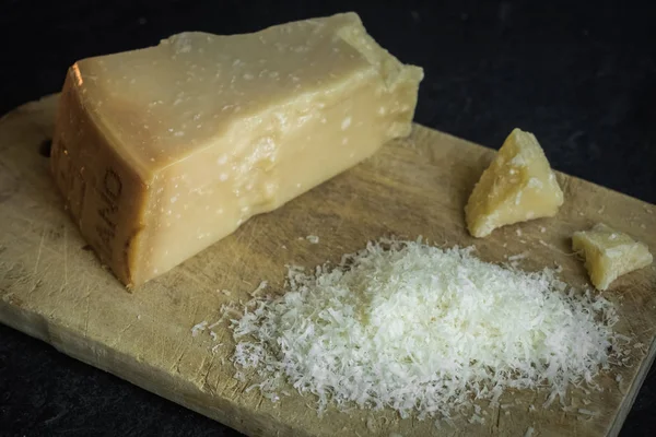 Тертый сыр пармезан на черном фоне, итальянская еда . — стоковое фото