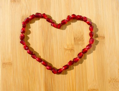 Kırmızı nar meyve. Olgun vejetaryen yemek. Tatlı sulu taze organik tohum ahşap arka plan kalbinde. Sağlıklı ham closeup tropikal yarım parça suyu ile. Lezzetli antioksidan tatlı.