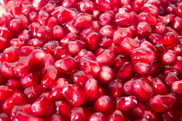 red grains of pomegranate close-up background texture