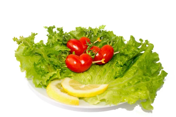Tre små röda tomat körsbär på den gröna isberg sallad och citron slidce — Stockfoto
