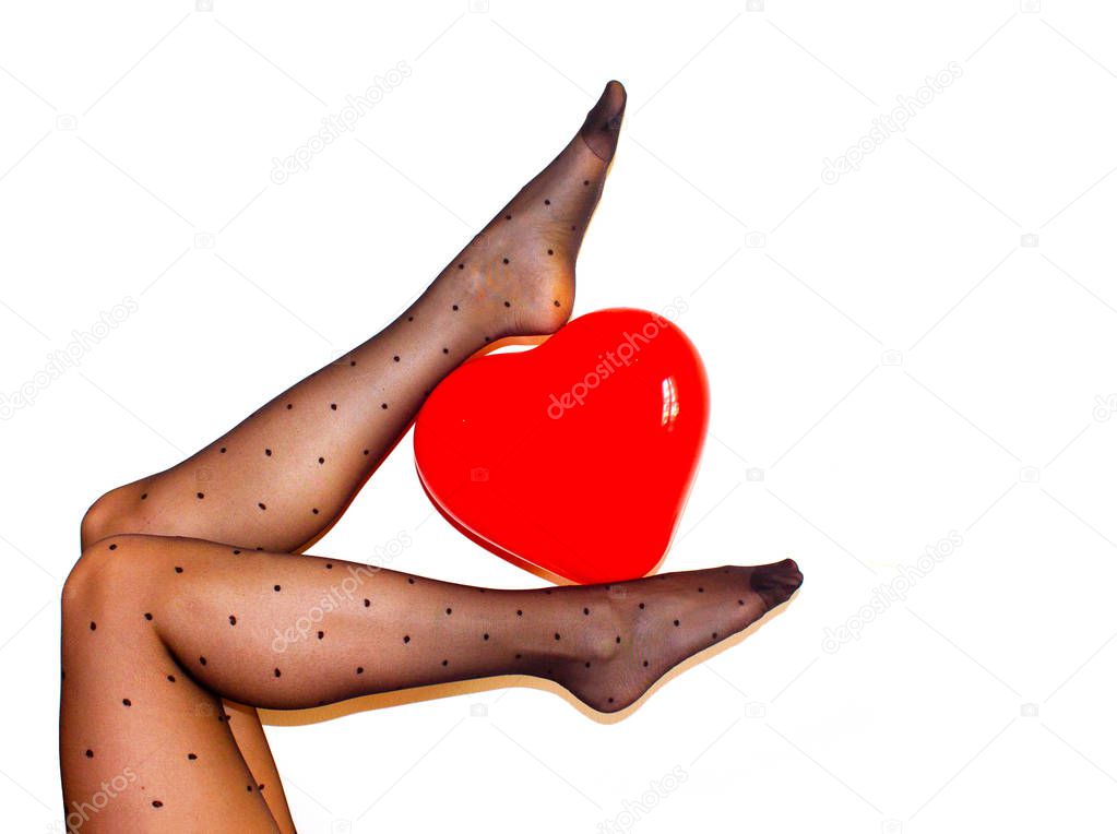 womens legs in black tights holding red heart ballon