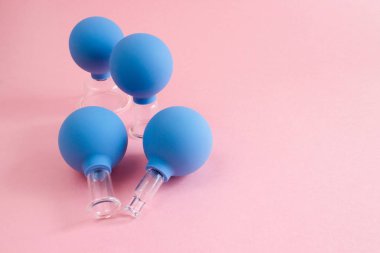 farklı boyutlarda dört mavi kozmetik vakum kavanoz cam ve kauçuk pembe bir arka plan üzerinde yapılan