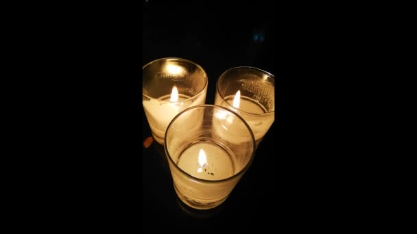 Три свечи в стакане — стоковое видео