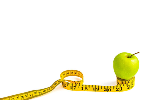 Green apple and measuring tape  with centimeters and inches