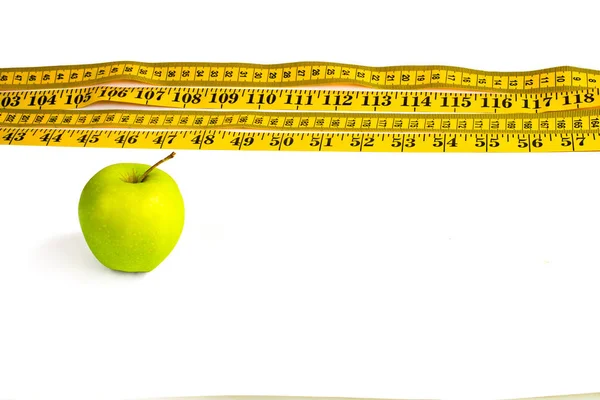 Grüner Apfel und Maßband mit Zentimetern und Zoll — Stockfoto