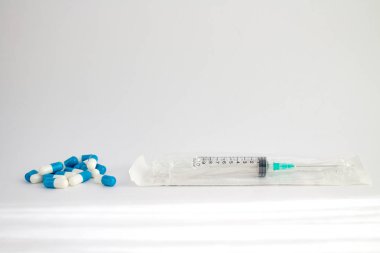 bir plastik paket ve birkaç hap bir iğne ile tıbbi şırınga
