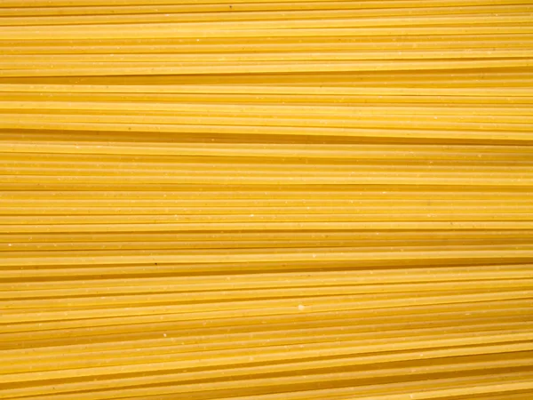 Фон длинной сырой желтой спагетти-пасты в хонтальной плоскости — стоковое фото