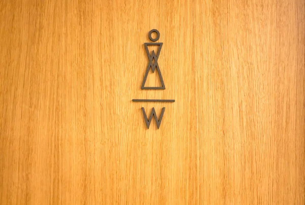Дизайнерський вказівник на жіночі туалети на дерев'яних дверях — стокове фото