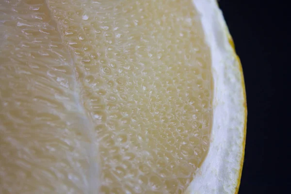 Fatia de fruta Pamela fresca madura tiro close-up em um fundo preto — Fotografia de Stock