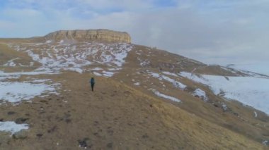 Bir turist trekking Polonyalılar ile ve bir arka plan bahar karla kaplı dağların büyük bir sırt çantası tırmanıyor bir üst ve bir termos çay içmeye bir durdurmak için durur. 4 k slowmotion. Hava