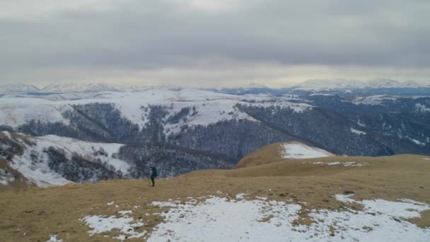 トレッキング ポールが観光と春の雪をかぶった山々 を背景に巨大なバックパック トップとポットからお茶を飲むを停止の位置に上昇します のスローモーション — ストック動画