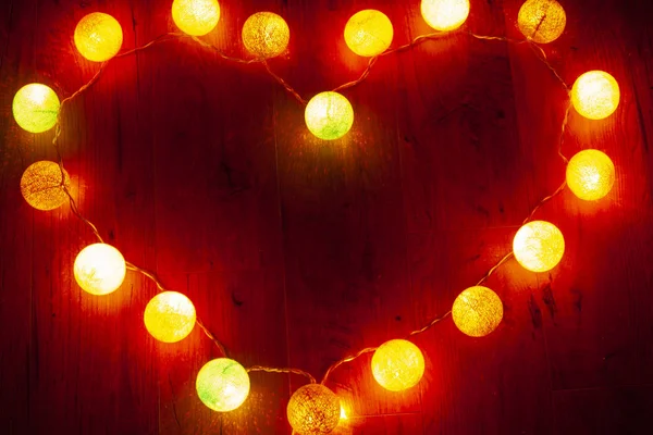 garland heart on wooden background,shining heart on Valentine's Day for loving couples