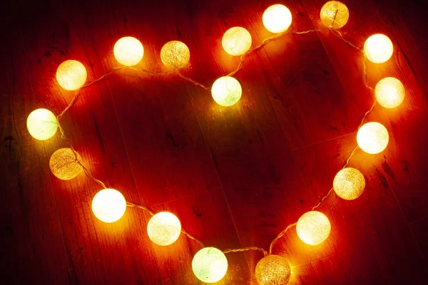 garland heart on wooden background,shining heart on Valentine\'s Day for loving couples