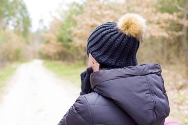 cep telefonuyla konuşan bir kız. kadın sıcak kış eldivenleri cep telefonu tutan hücresel iletişim kurar 