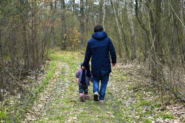 Pai e filha foram dar um passeio na floresta de primavera. pai e menina relaxar na natureza no início da primavera . — Fotografia de Stock