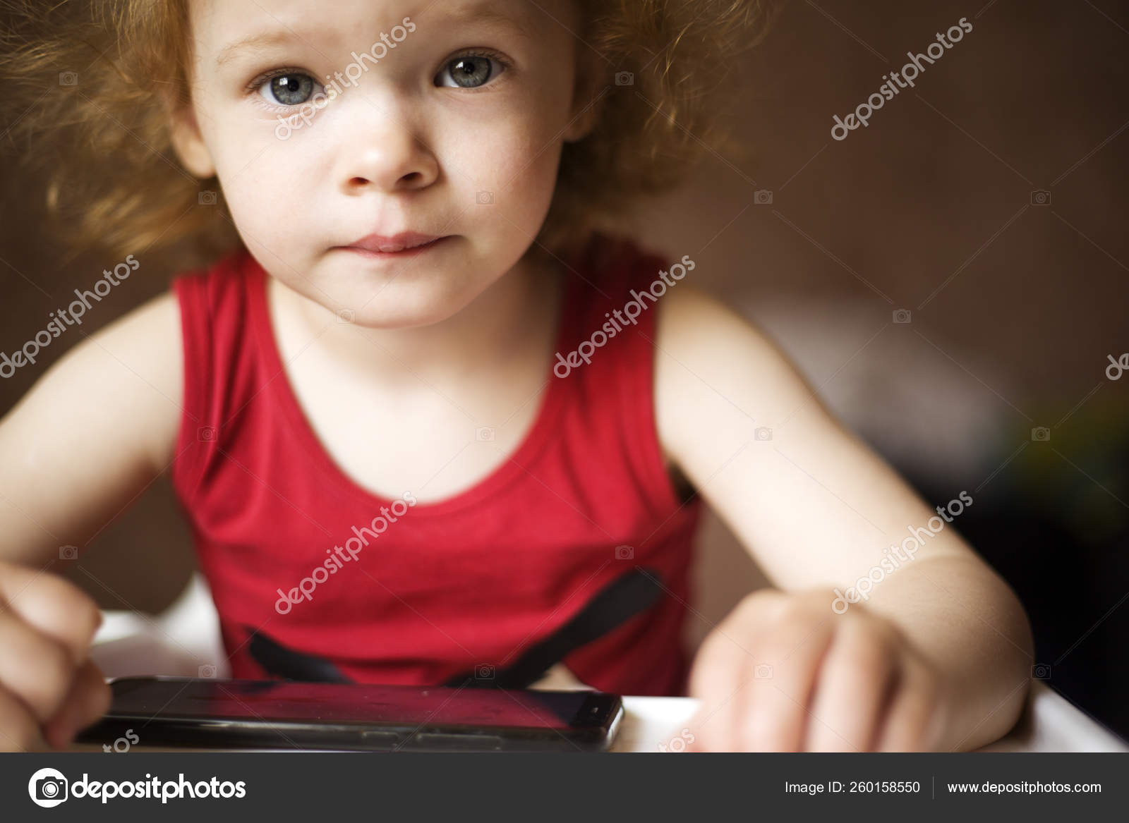 Rousse Petite Fille Regarde Des Dessins Animes Au Telephone Un Beau Bebe Jouant A Des Jeux Au Telephone Image Libre De Droit Par Fukume C
