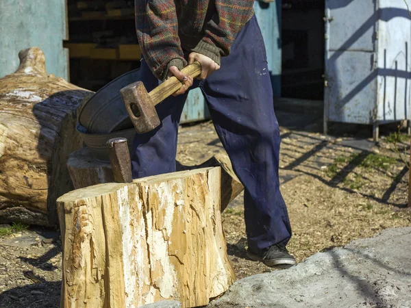 Ragazzo nel villaggio tagliare ceppi di quercia con una zeppa e mazza, la raccolta di legno — Foto Stock