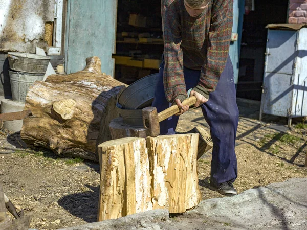 Ragazzo nel villaggio tagliare ceppi di quercia con una zeppa e mazza, la raccolta di legno — Foto Stock