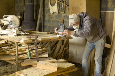Bir adam bir ağaç atölyesinde odun işçisi değirmenleri, bir frezeleme makinesi ile bir solunum bir marangoz