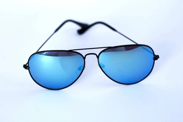 Синие зеркальные солнцезащитные очки с антибликовым покрытием и защитой от ультрафиолета на белом фоне . — стоковое фото