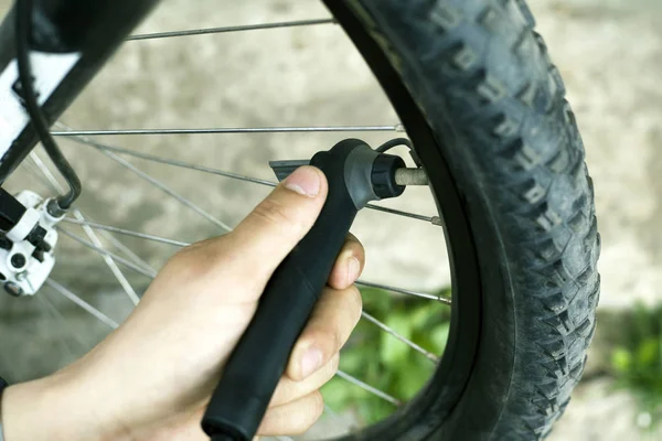 Bomba manual. El tipo sacude un neumático pinchado de una bicicleta de montaña. rueda de bicicleta —  Fotos de Stock