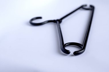 beyaz bir arka plan üzerinde siyah giysi askısı.