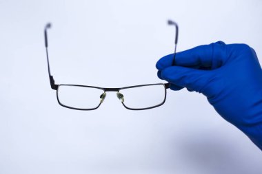 göz doktoru hastaya lensler alır. Düşük görme için astigmatik gözlükler. tıbbi eldiven beyaz arka plan üzerinde