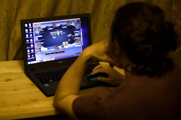 Kiev, Oekraïne 05.12.2019: meisje spelen online poker voor laptop illustratieve redactionele — Stockfoto