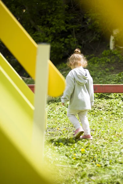 Linda menina correndo ao redor do playground de sua mãe — Fotografia de Stock