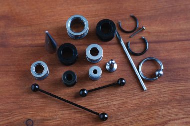 Ahşap arka plan piercing Piercing aksesuarları için ayarlayın. dil ve kaş, küpe bir çubuk için bir kateter   