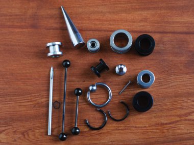 Ahşap arka plan piercing Piercing aksesuarları için ayarlayın. dil ve kaş, küpe bir çubuk için bir kateter   