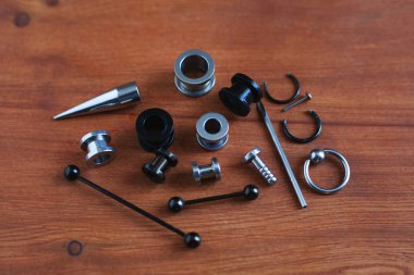 Ahşap arka plan piercing Piercing aksesuarları için ayarlayın. dil ve kaş, küpe bir çubuk için bir kateter   